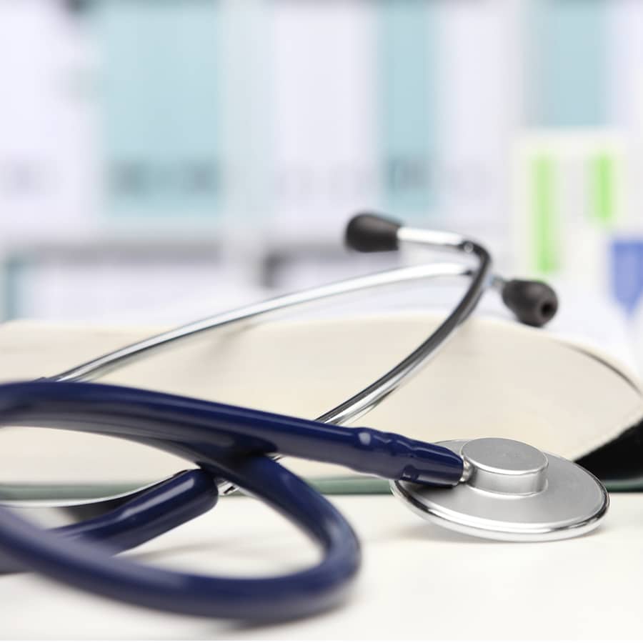 doctor desk with medical equipment, stethoscope and clinic tonometer, blood pressure measurement, drugs in background